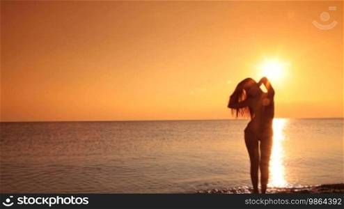 Silhouette of a young woman enjoying the golden sunset