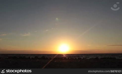 Silhouette of runner athlete jogging at seaside twilight time. Sportsman running on seashore in glow of orange setting sun. Jogger man running on the beach at sunset. Slow motion.