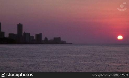 Skyline, buildings and sunset on the ocean in the city of Havana, Cuba. Sequence