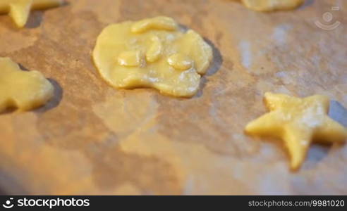 Slow motion clip of the woman's hand putting pastry dough molds on the parchment paper