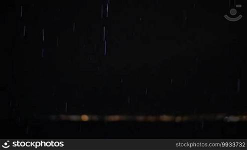 Slow motion of falling rain drops and flash of lightning outdoor at night