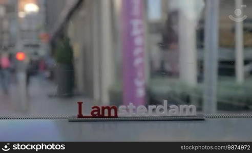 Slow motion shot of traveling by bus or tram in Amsterdam. View to the streets with people through the window with city slogan, Netherlands