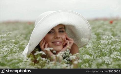 Smiling Face Of a Young Woman In a Blossoming Field. Looking At Camera