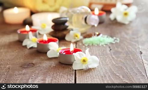 Spa still life of massage oil, towel, rocks, and flowers