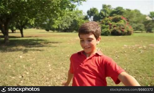 Sport, children, young people, and recreation with a white Hispanic child playing soccer, boy, and football game in the park, training.