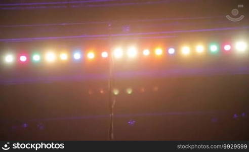 Steadicam shot of overhead stage soffits lighting with different colors.