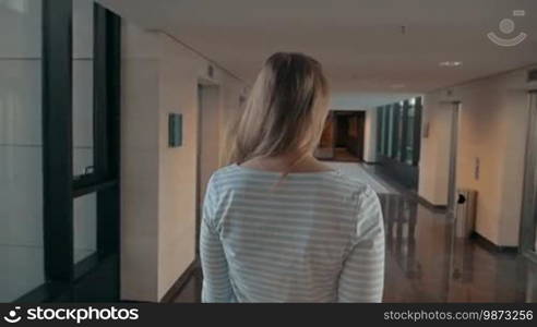 Steadicam slow motion shot of happy young woman coming home with many shopping bags.