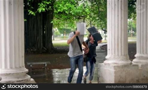 Students talking and smiling, boy and girl running in the rain during storm. Sequence