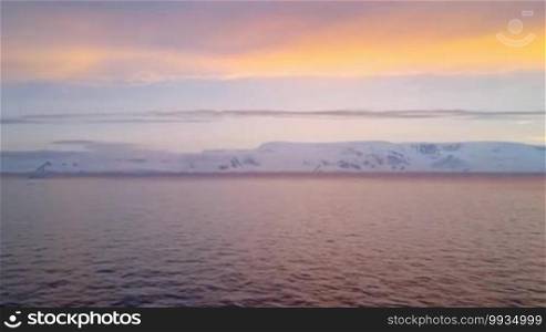 Sunrise over Brabant Island, Gerlache Strait, Antarctica. Brabant Island is the second largest island in the Palmer Archipelago. Large ice-cliffs protect its coastline from the sea.