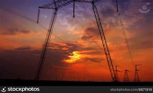 Sunset with electricity pylon. Time lapse.
