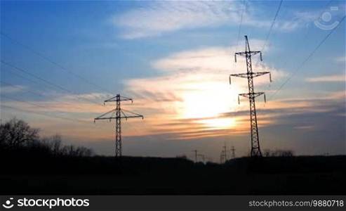 Sunset with electricity pylon. Time lapse.