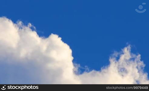 Swirling white clouds on a background of deep blue sky