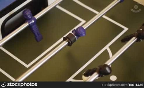 Table soccer - striker has the ball and dribbles faster than defender and keeper can hold. Tischfussball, Kicker - the striker in the three-row has the ball and dribbles until he finds a gap to score a goal