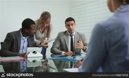 Team of business people working and talking during a meeting in an office room. 2 of 20