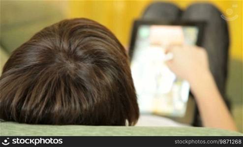 Teen Boy Using a Touch Screen Tablet PC At Home, Closeup