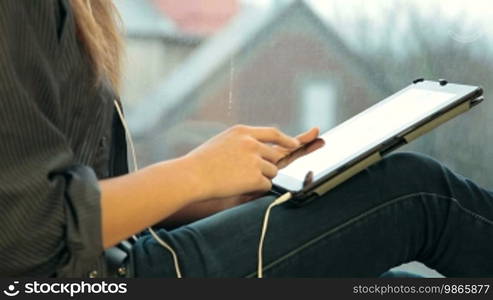 Teenager Girl Using Digital Tablet, Listening to Music