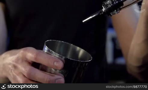 The barman prepares a set of cocktails on the bar counter.