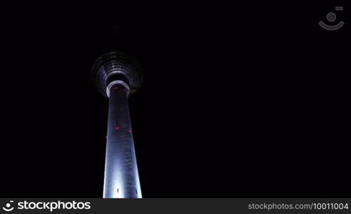 The Berlin TV Tower in the eastern center of Berlin, brightly illuminated and lit up at night.