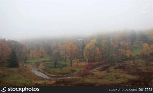 The fog is coming on forest with curving river. Time lapse. Toila, Estonia.