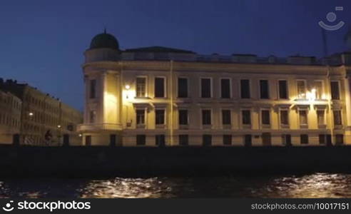 The man on a bicycle is going along the quay of the Moika River in Saint Petersburg.