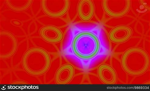 The pattern from yellow rings with a magenta star slowly changes on a bright red background.