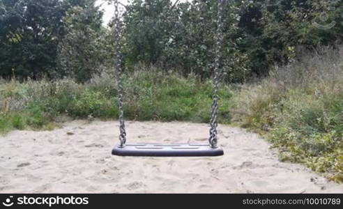 The scene shows an empty swing that no longer swings. Instead, the chains are still swaying slowly.