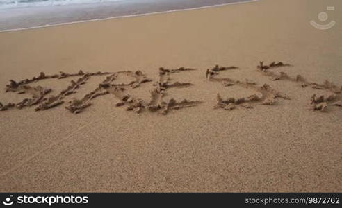 The word "stress" written in the sand on the beach