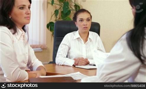 Three Young Women Discussing Business Issues in Office