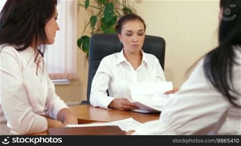 Three young women discussing business issues in office
