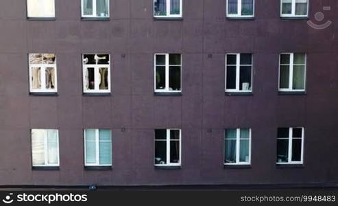 Tilt shot of multistorey apartment block with sun flare in some windows