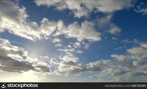 Time lapse clip of white fluffy clouds over blue sky