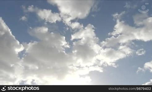 Time lapse clip of white fluffy clouds over blue sky