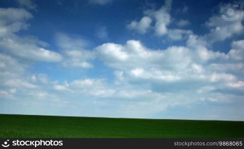 Time lapse green field and moving clouds.