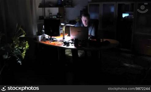Time lapse. Man works on computer at night.