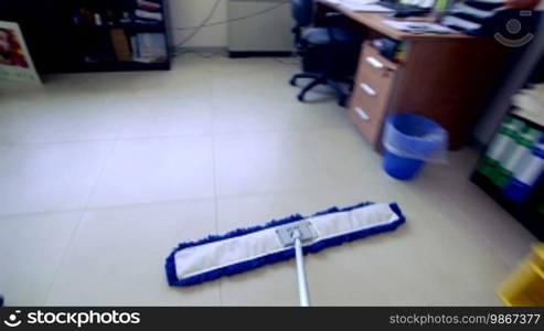 Time-lapse of professional cleaner wiping and cleaning floor with mop in industrial building