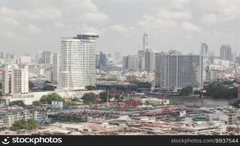 Time lapse shot of construction building area on the foreground and cityscape with skyscraper on the background, Bangkok, Thailand