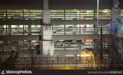 Timelapse of night city traffic on the road near the parking deck