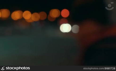 Timelapse of traffic lights in the city at night. Defocused shot of moving cars and people