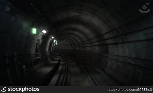 Timelapse shot of a subway train moving in the dark tunnel and making stops at the stations, view from the cabin. Paris, France