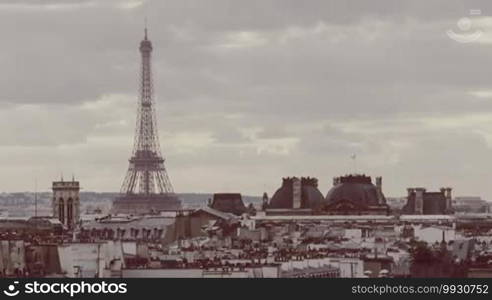 Timelapse shot of grey clouds floating over Paris with zooming in on the Eiffel Tower