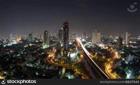 Timelapse shot of night Bangkok, the capital of Thailand. Transport traffic in illuminated streets with urban architecture