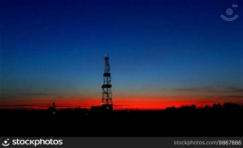 Timelapse silhouette of a land drilling rig.