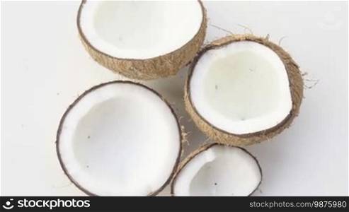 Top view closeup of coconuts isolated on the white background - video in slow motion