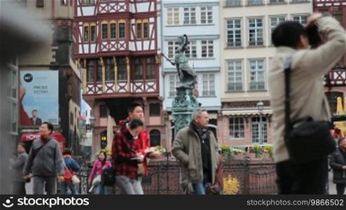 Tourists at the Fountain of Justice with the fountain figure Justitia, at Römerberg. (Frankfurt am Main)