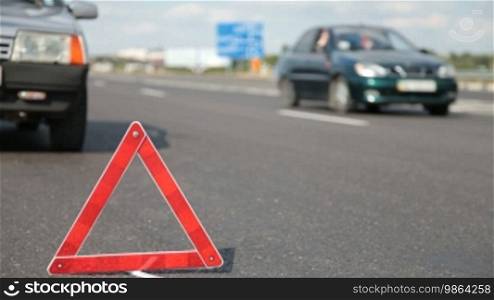 Triangle indicating car damage on the road.