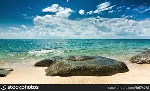 Turquoise sea waves breaking on the stone near the beach