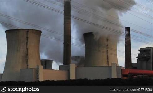 Two towers of a coal power plant emit massive smoke