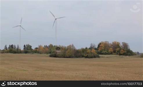 Two wind turbines in the field. Green energy.