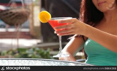 Unrecognizable woman drinking cocktail in restaurant