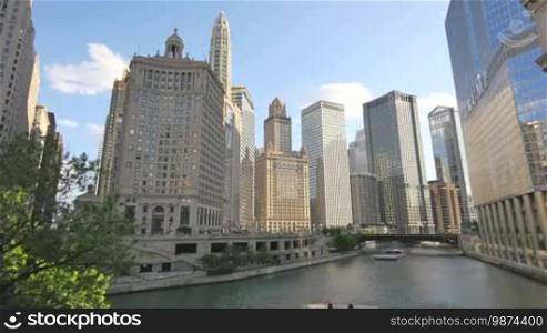 Video timelapse of Chicago downtown skyscrapers at the city center financial district in the United States of America. View of the Chicago River from the Michigan Bridge at Sunset. Clouds crossing the sky reflected on the facade glasses.